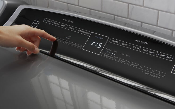 A washer and dryer set in a large, dark laundry room.
