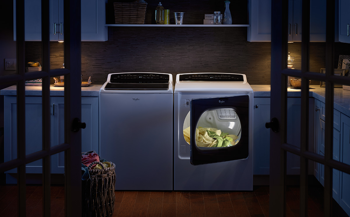 A washer and dryer set in a large, dark laundry room. A washer and dryer set in a large, dark laundry room.