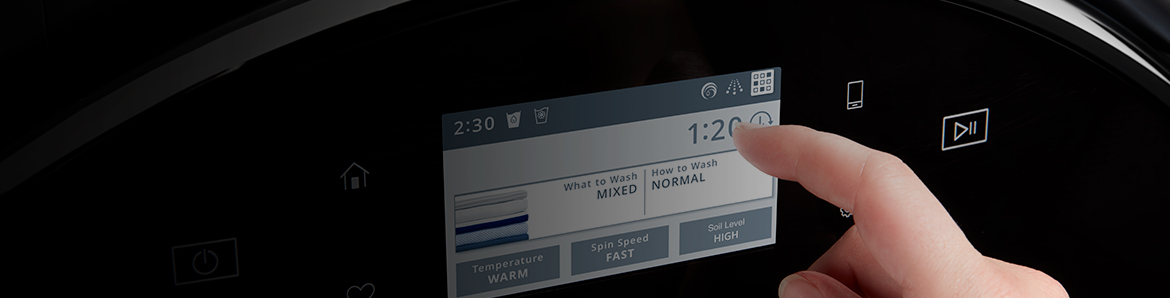 Personne appuyant sur un bouton de sa laveuse Whirlpool.