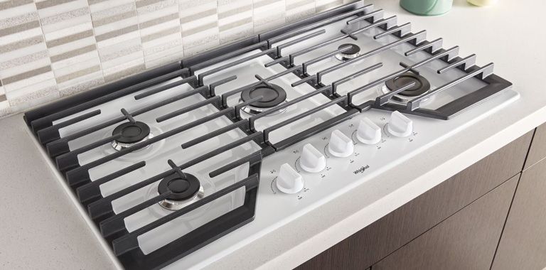 Whirlpool Gas Cooktop Range Installed On White Counter With Grey Backsplash