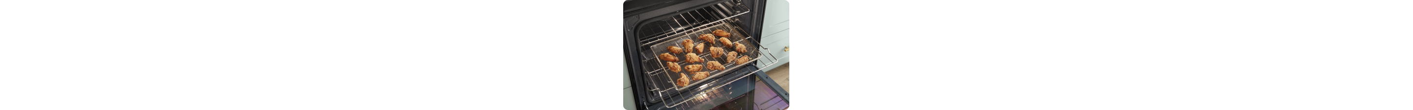 An opened Whirlpool Oven with the middle rack pulled out. On the rack is an air fry basket filled with chicken wings