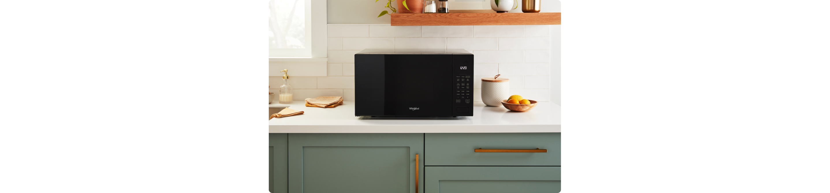Un four à micro-ondes Whirlpool dans lequel cuisent des aliments. À proximité se trouvent des planches à découper et des étagères contenant des objets comme des verres