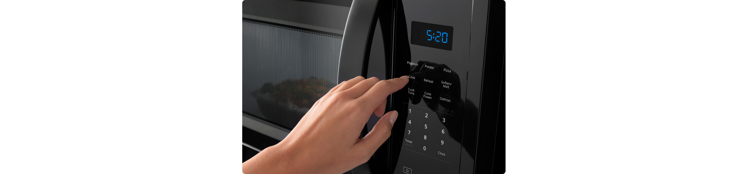 Une personne appuie sur le bouton d'un four à micro-ondes Whirlpool. L'heure indique 5:20