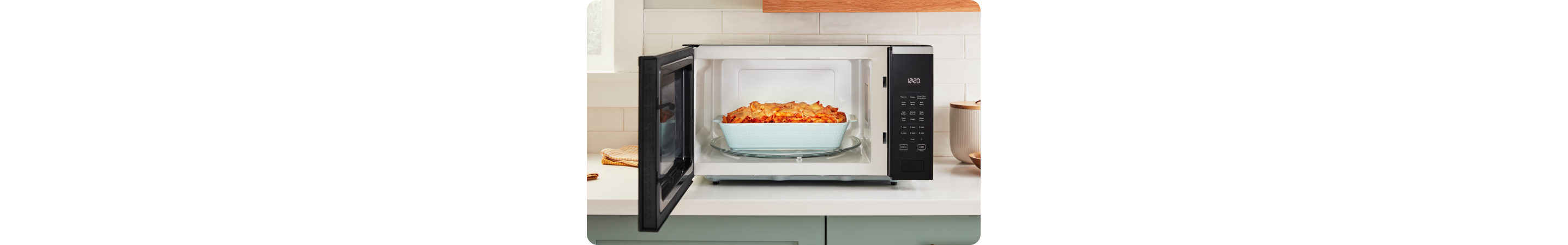 Un four à micro-ondes Whirlpool ouvert avec une casserole sur le plateau tournant