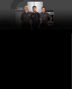 Three professionals in uniform stand in front of a Whirlpool laundry appliance, Whirlpool oven, and Whirlpool refrigerator