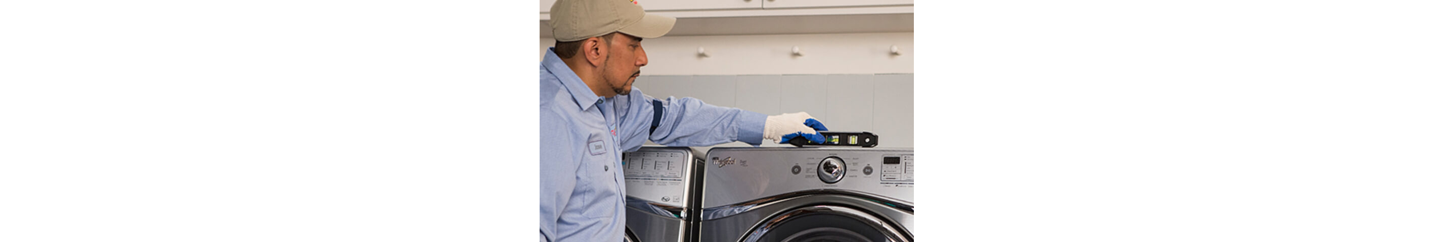  A person installs a new washer in a laundry room. It checks if the device is level.