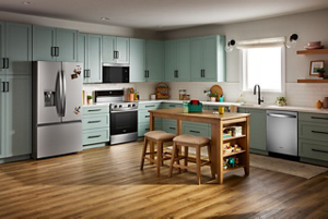 Une cuisine avec un réfrigérateur Whirlpool, une cuisinière Whirlpool et un four à micro-ondes à hotte intégrée, ainsi qu'un lave-vaisselle Whirlpool. On voit également un îlot en bois avec deux tabourets.