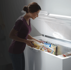 Person taking food out of an open chest freezer