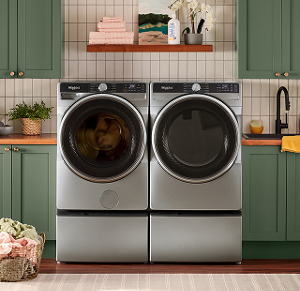 A Whirlpool® Washer and Dryer set surrounded by green cabinetry