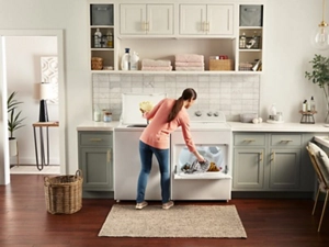 Person moving laundry from a washer to a dryer