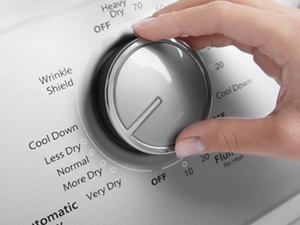 Hand turning a dryer control knob