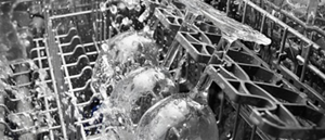 A closeup of wine glasses being cleaned in a dishwasher