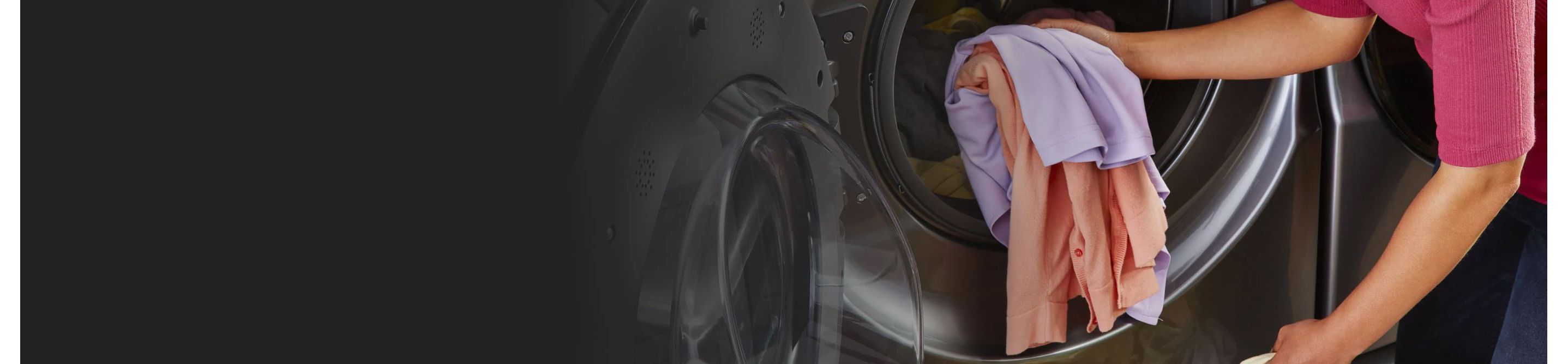 A person places some articles of clothing in a Whirlpool Front-Load Washer
