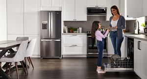 A mother and daughter unloading the dishwasher